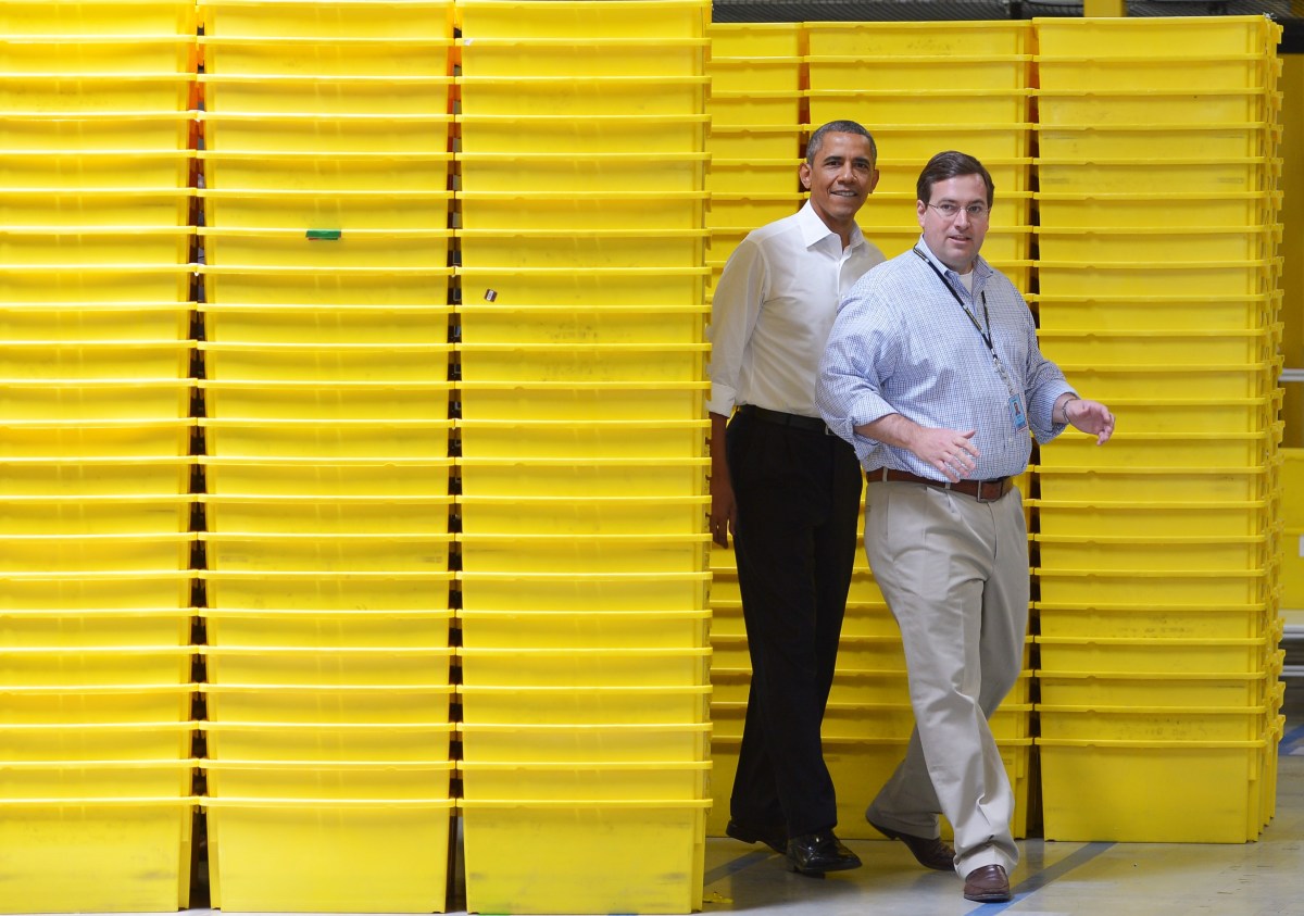 US President Barack Obama emerges from behind a stack of packing bins as he tours an Amazon fulfillment center with Amazon's Vice President for Worldwide Operations Dave Clark on July 30, 2013 in Chattanooga, Tennessee. AFP PHOTO/Mandel NGAN (Photo credit should read MANDEL NGAN/AFP via Getty Images)