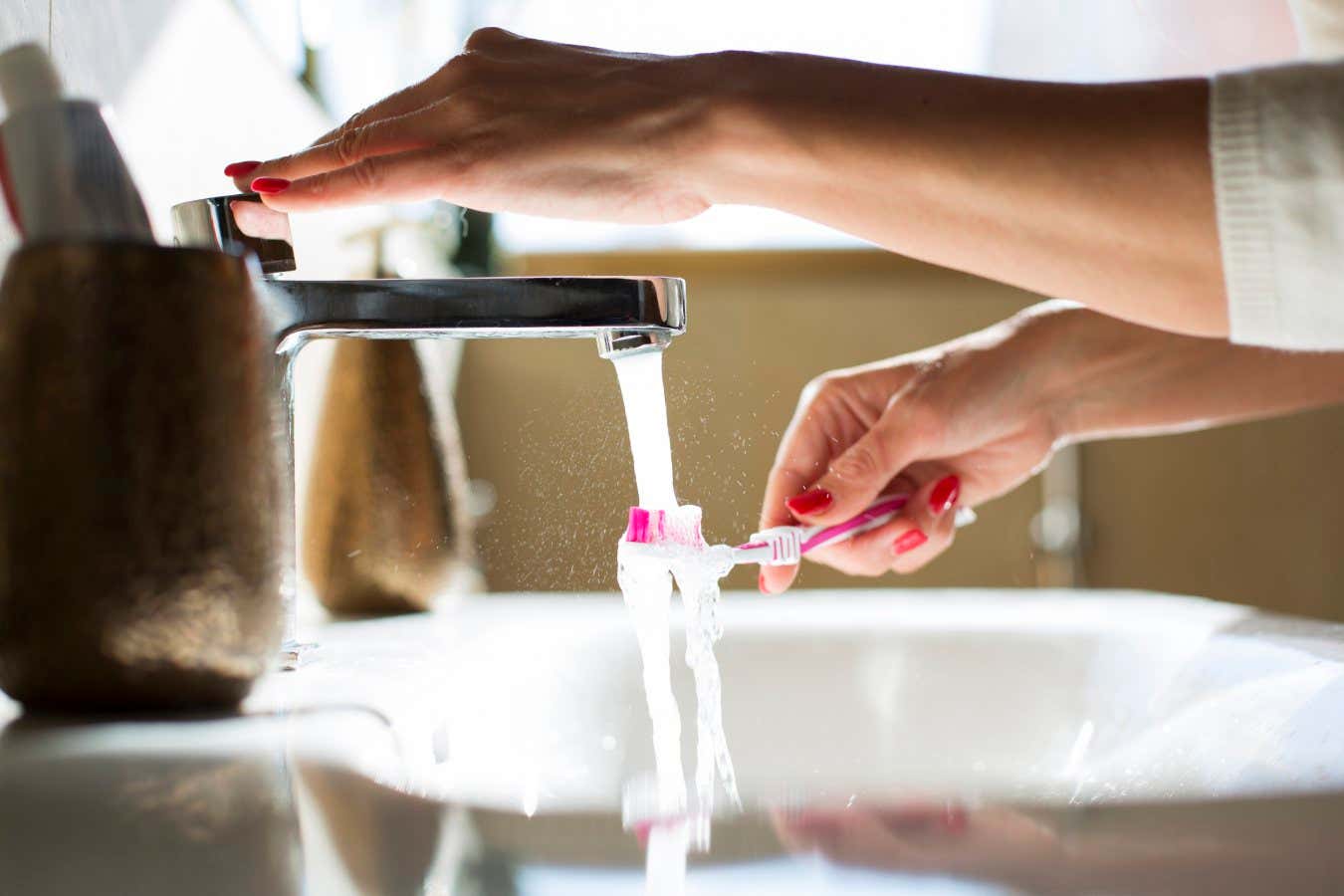 A woman rinsing her toothbrush